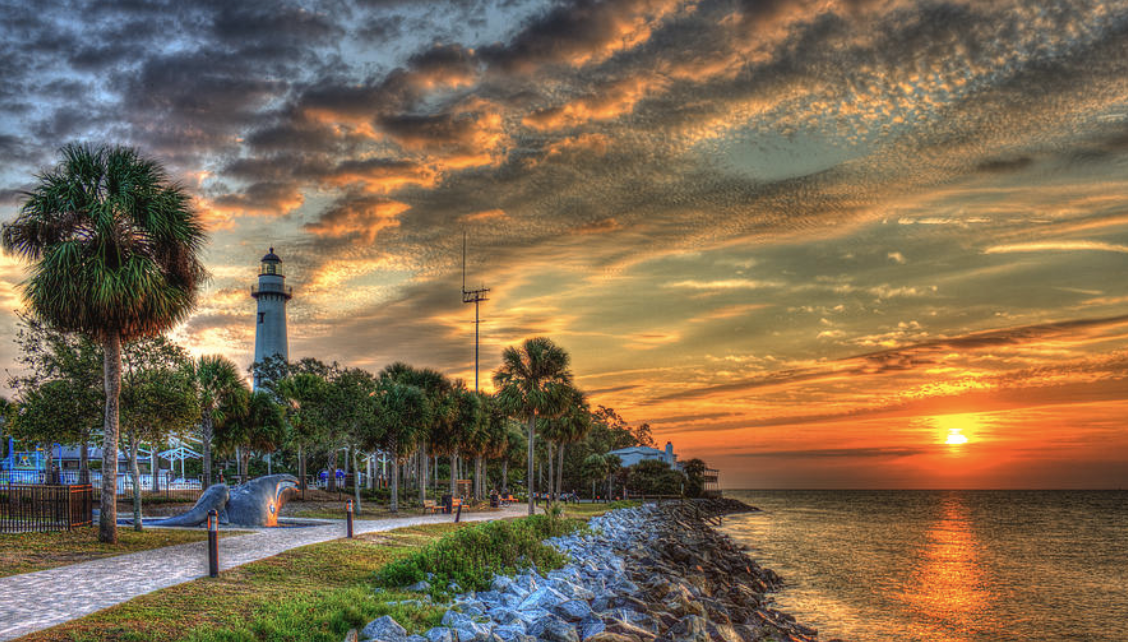 sunset over water with lighthouse