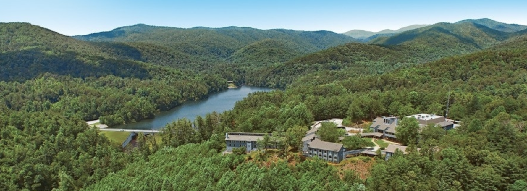 drone shot of lodge within trees